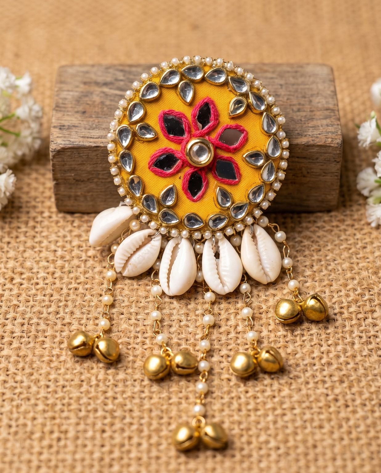 Handmade Kanak mustard mirror hair brooch with pink thread floral work and cowrie shells