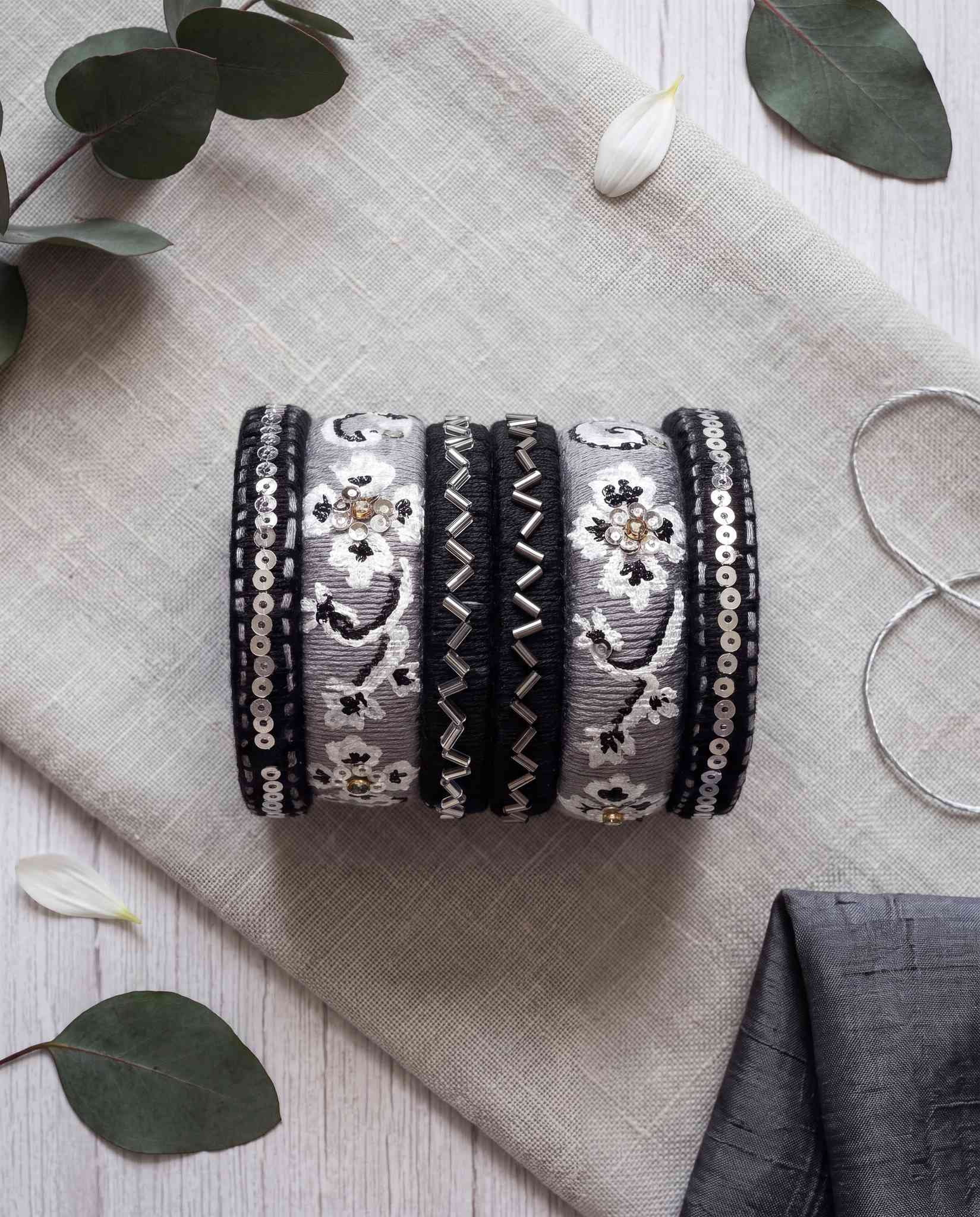 Black and grey silk thread bangles styled with eucalyptus leaves and white petals