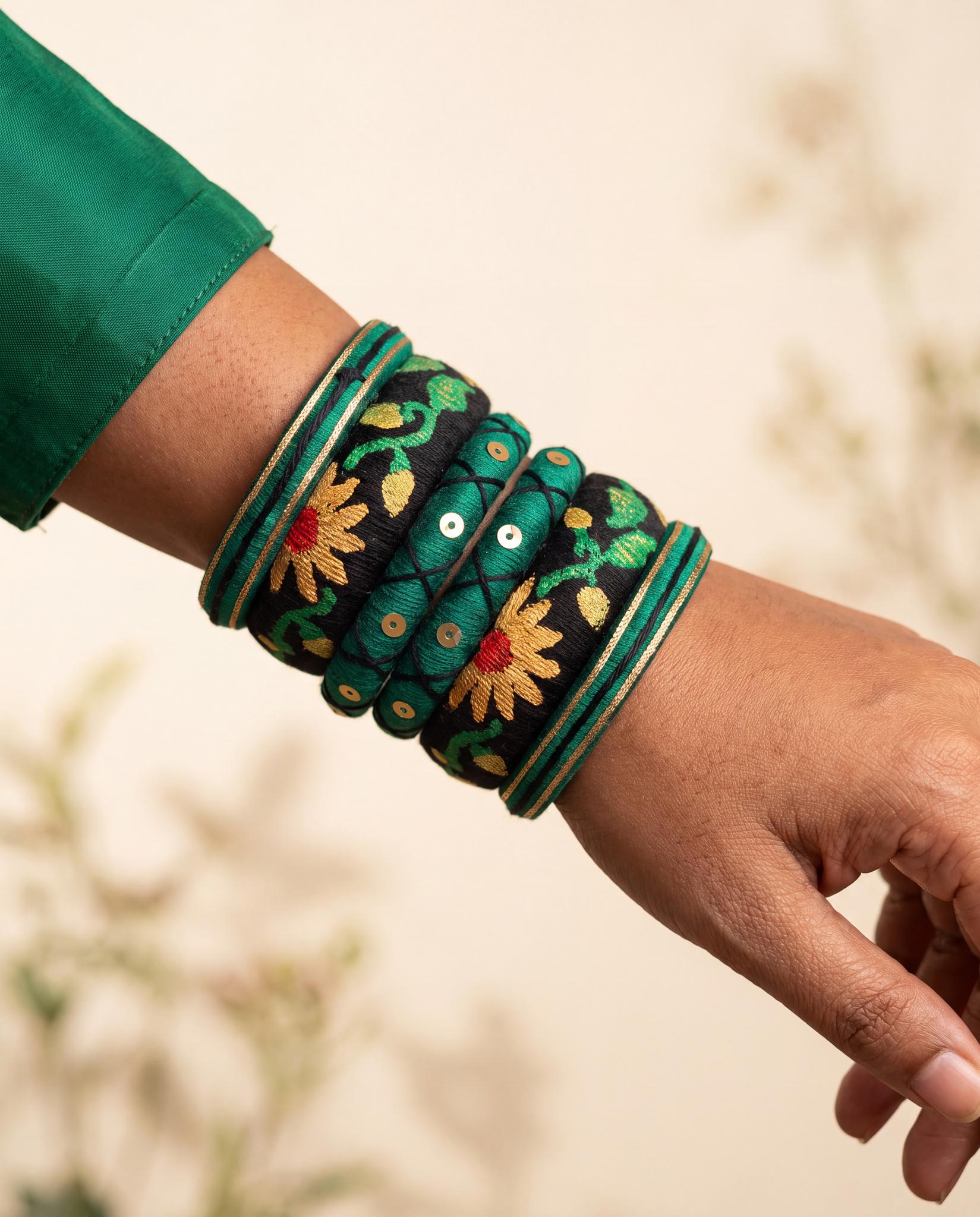 Woman wearing green and black silk thread sunflower bangle set on wrist