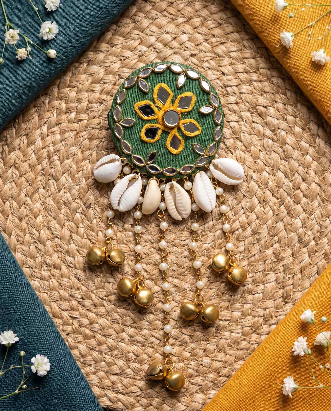 Green mirror hair brooch with gold bells, alternate styled view on woven jute mat