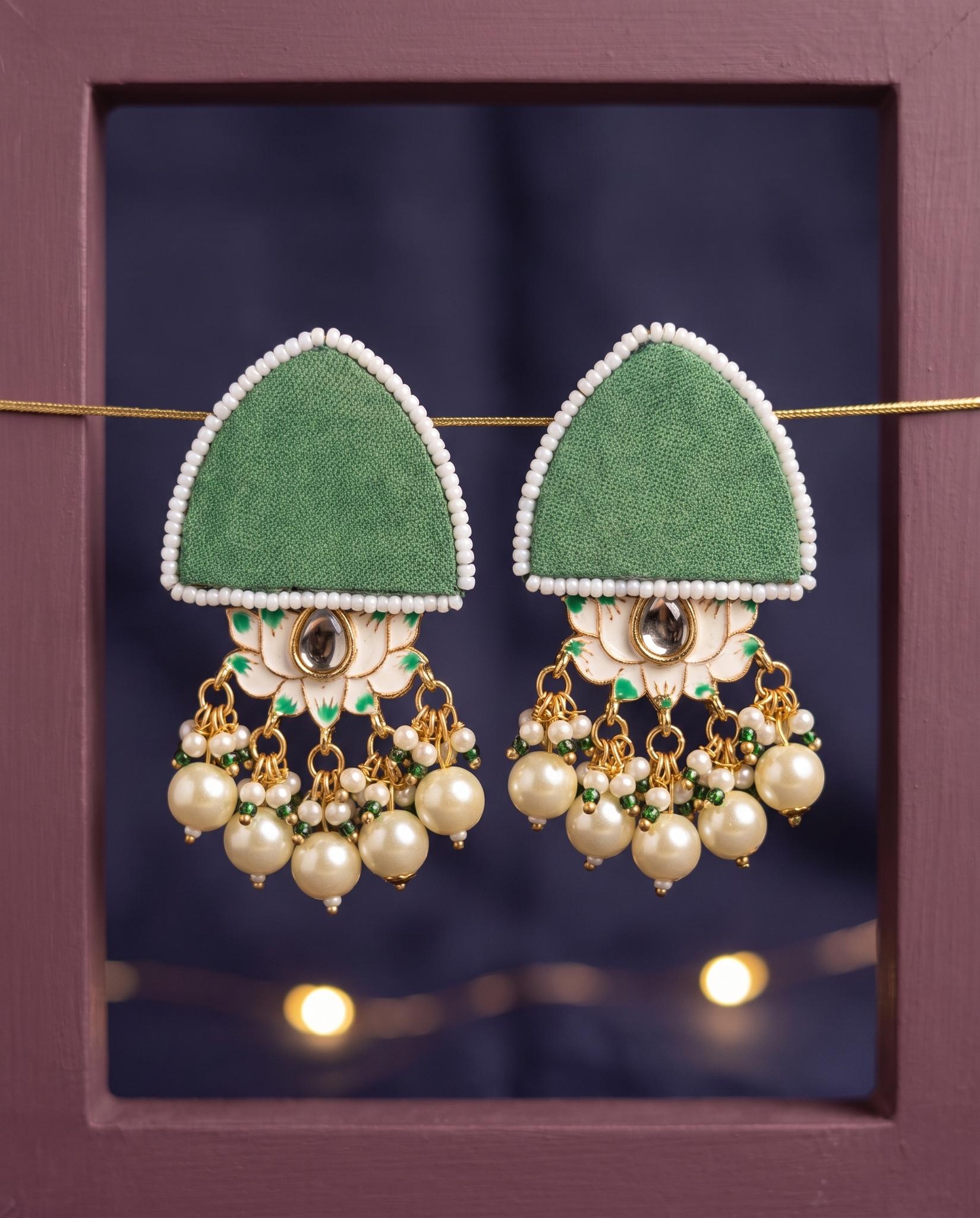 Green pearl floral earrings displayed in mauve frame with fairy lights