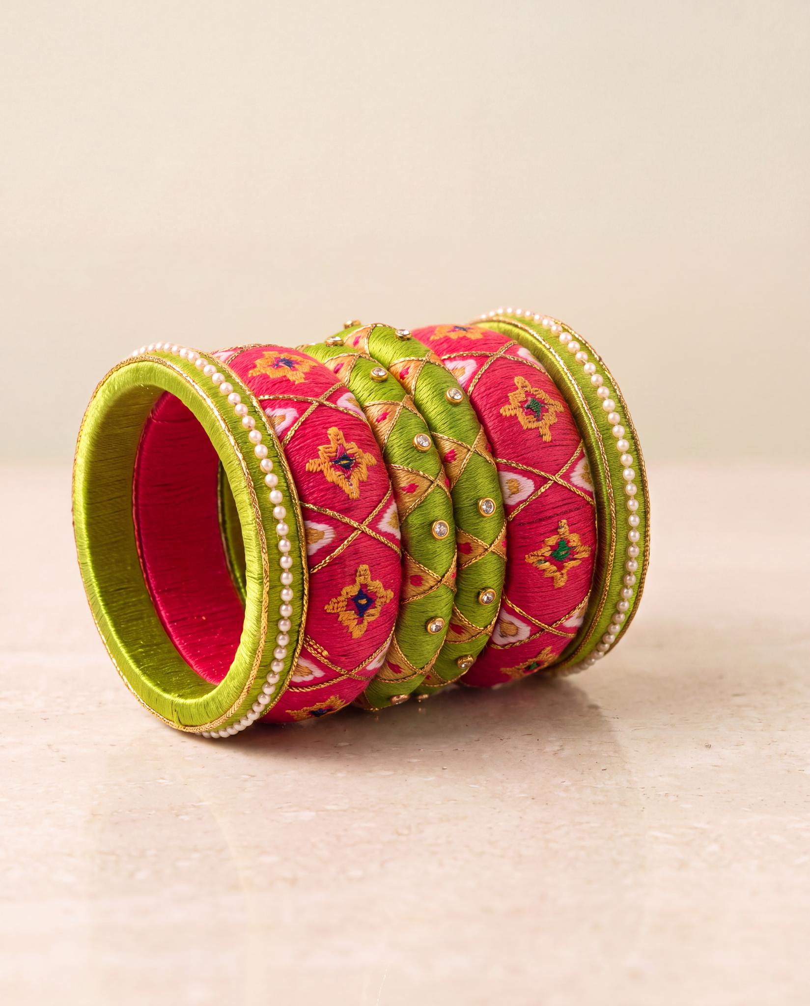 Green and pink silk thread bangles with bandhani pattern displayed at an angle