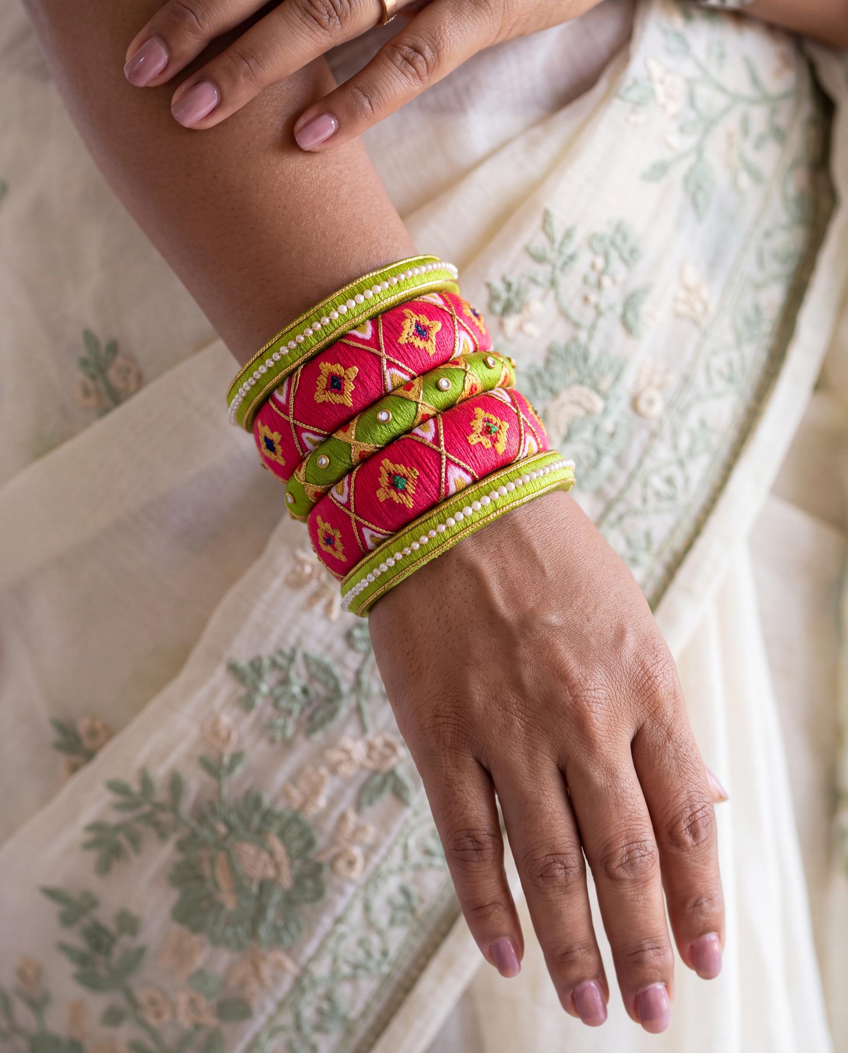 Woman wearing green and pink bandhani print silk thread bangles stacked on wrist