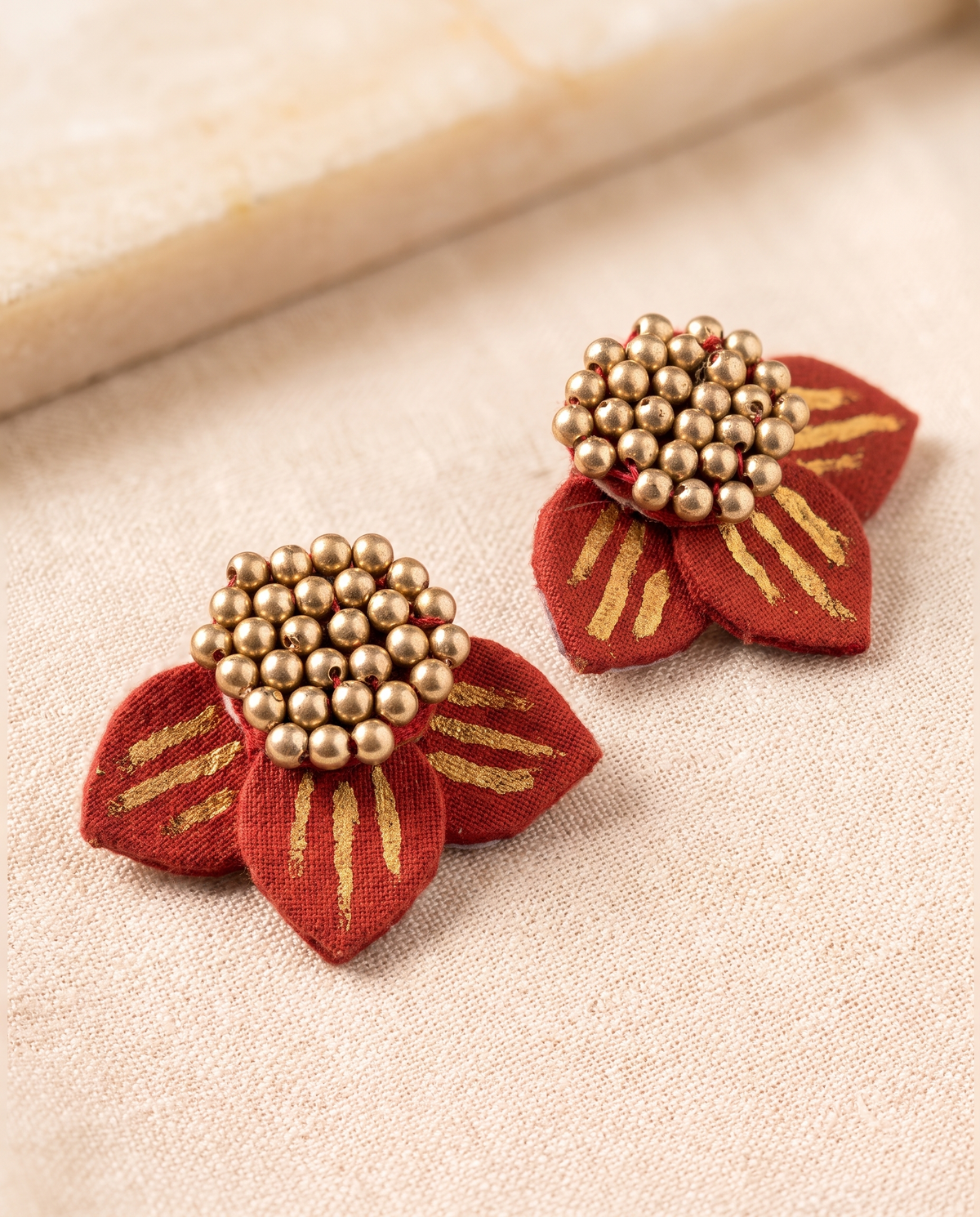 Handmade red fabric floral stud earrings by KEVILAGU with gold thread detailing and gold bead cluster