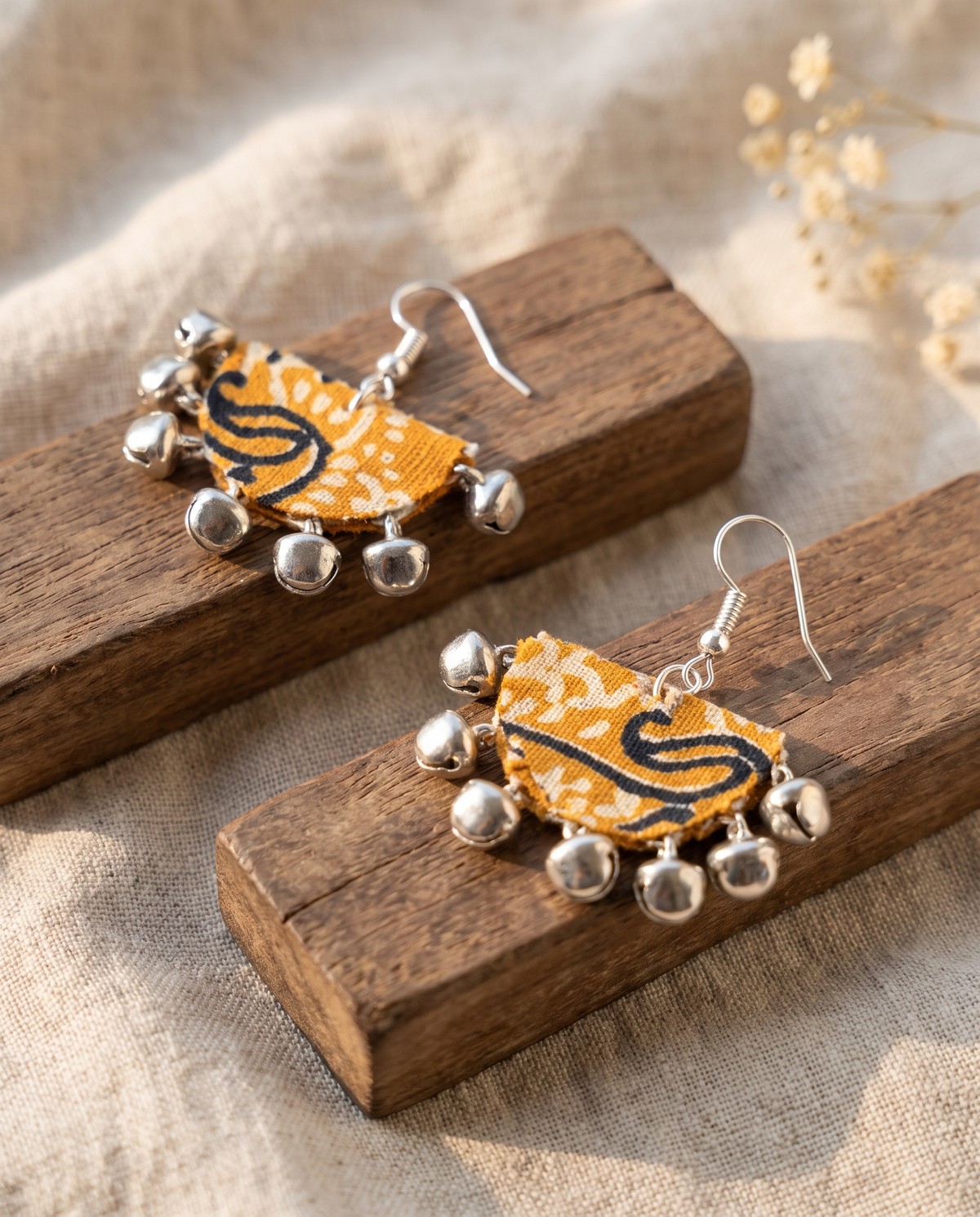 Handmade mustard, black & white paisley block-print fabric ghungroo dangle earrings by KEVILAGU with silver bell fringe