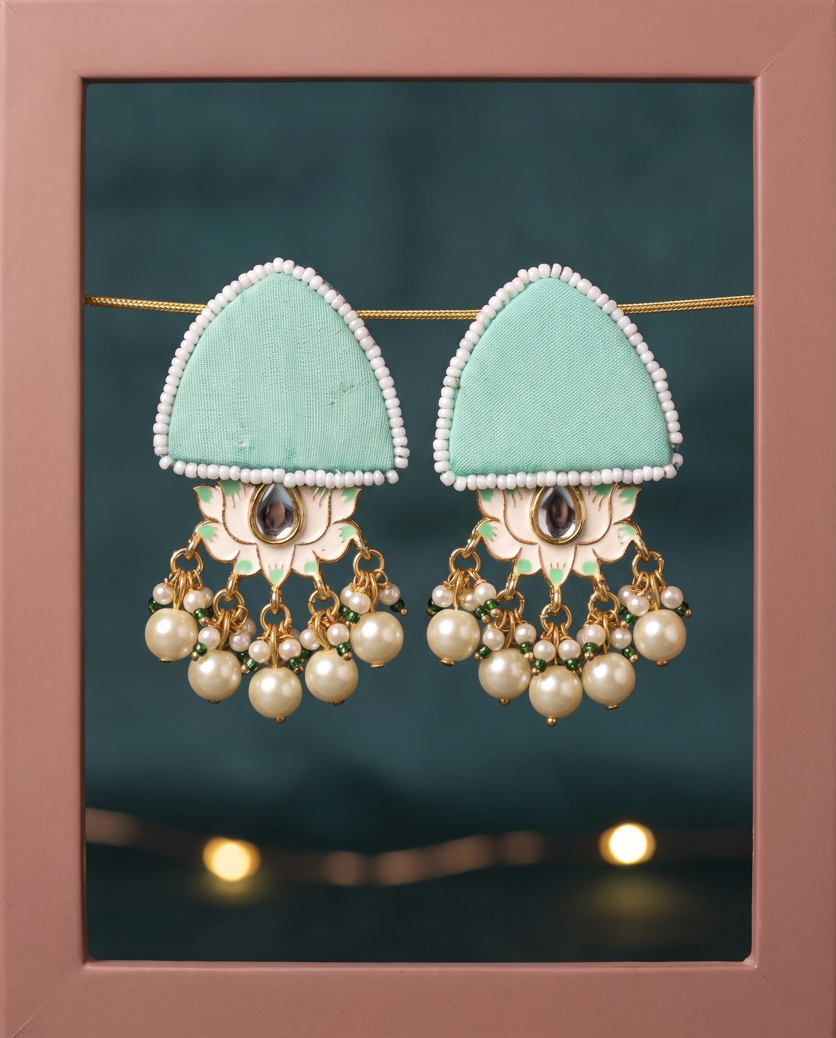 Mint green pearl floral earrings displayed in pink frame with fairy lights