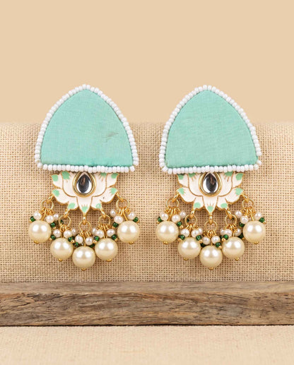 Mint green fabric floral earrings with pearl tassels on jute weave background