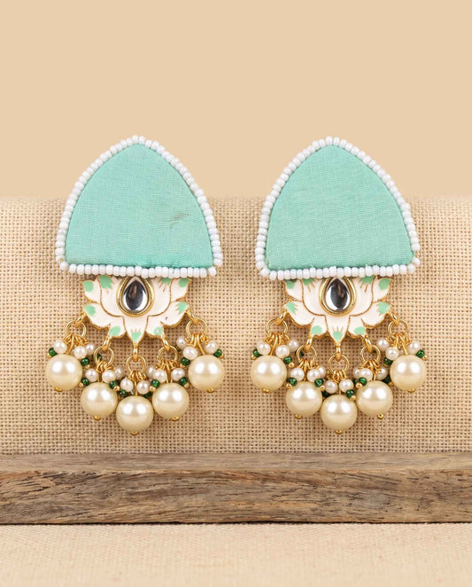 Mint green fabric floral earrings with pearl tassels on jute weave background