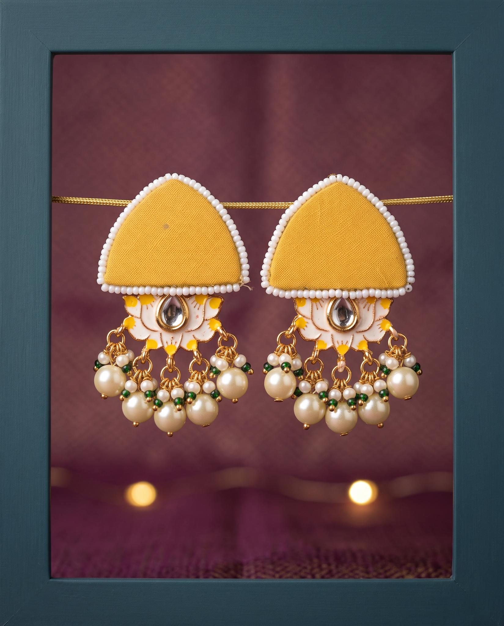 Mustard yellow pearl floral earrings displayed in teal frame with fairy lights