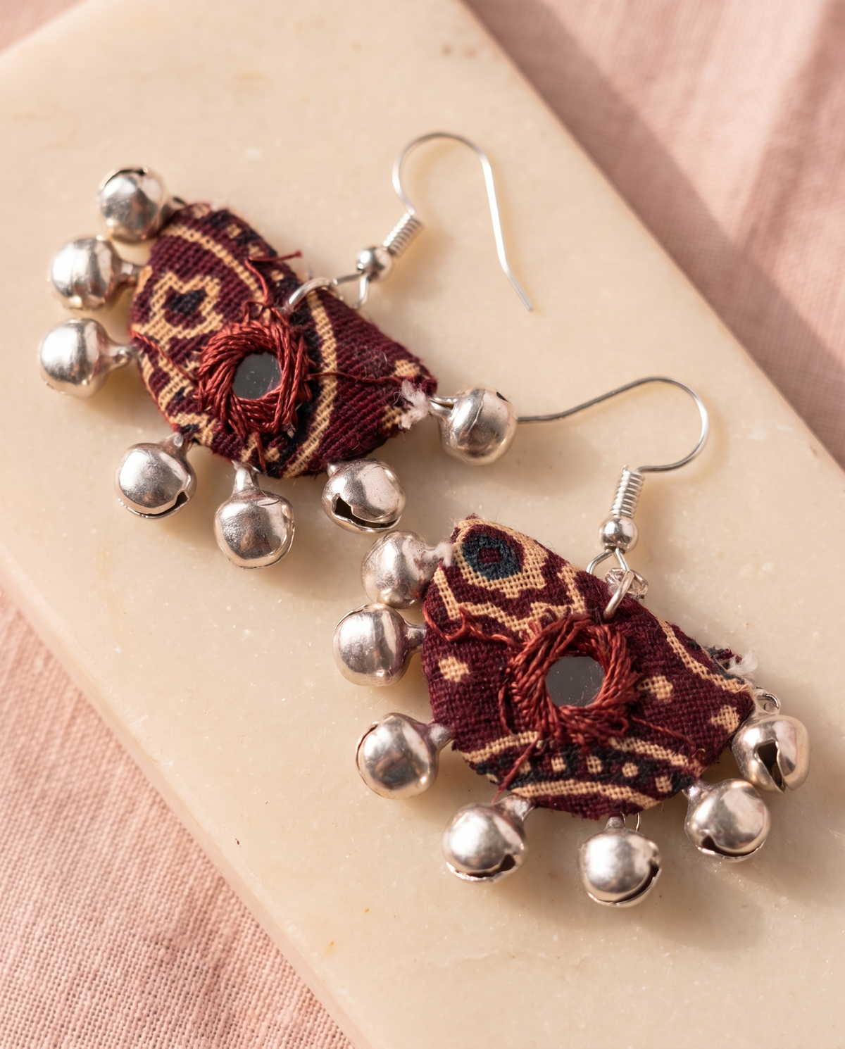 Handmade maroon & beige block-print fabric ghungroo dangle earrings by KEVILAGU with mirror-work accent and silver bell fringe