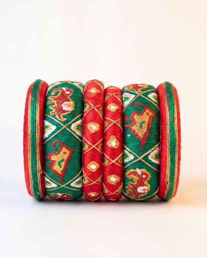Red and green silk thread bangle set with embroidered elephant motif on plain background
