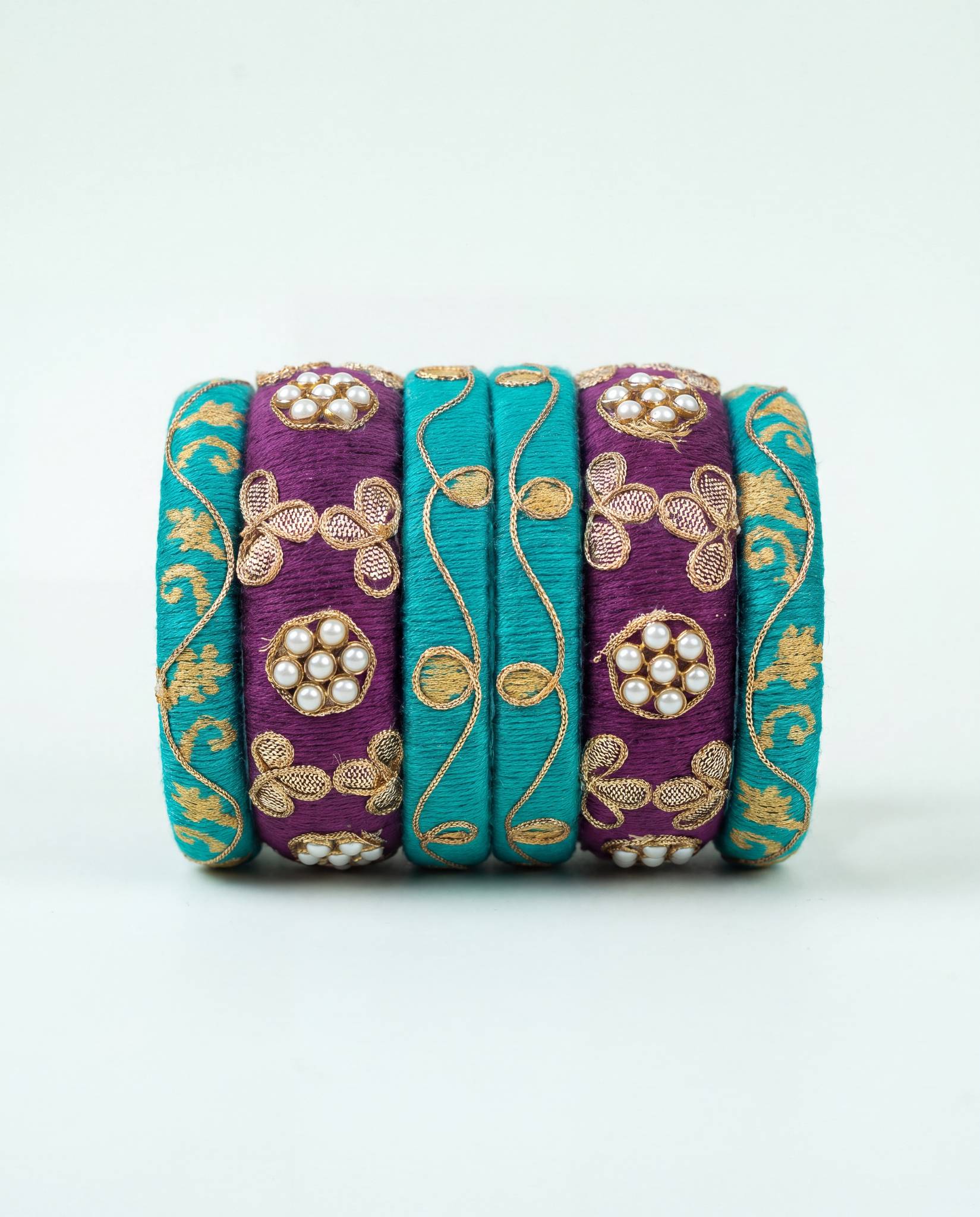 Teal and plum silk thread bangle set with golden zari and kundan pearl detailing